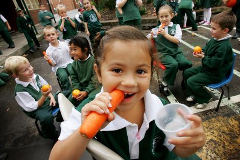 Primary school students snack on fruit and vegetables as part of the Sip and Crunch program.